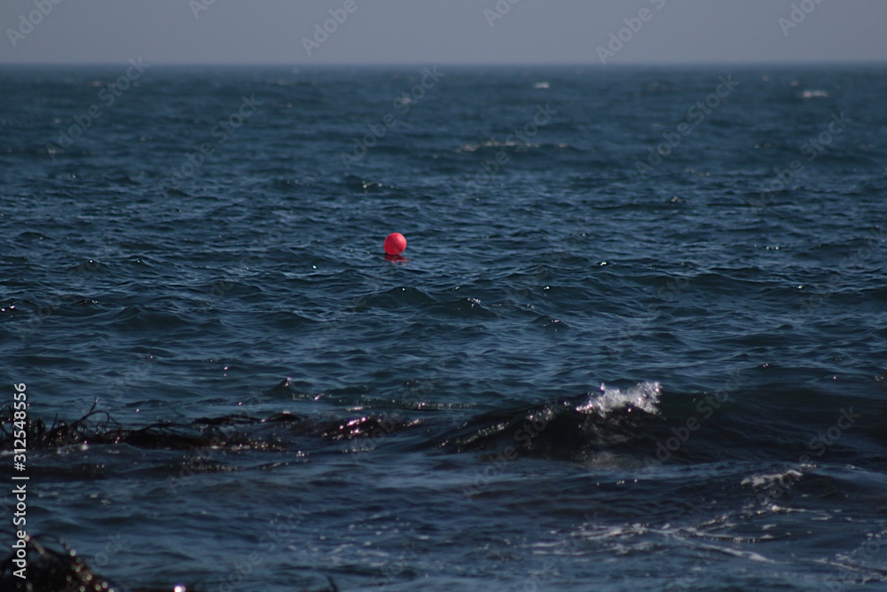 A red balloon in the middle of the ocean. A photo taken in Algarrobo Beach, Chile.