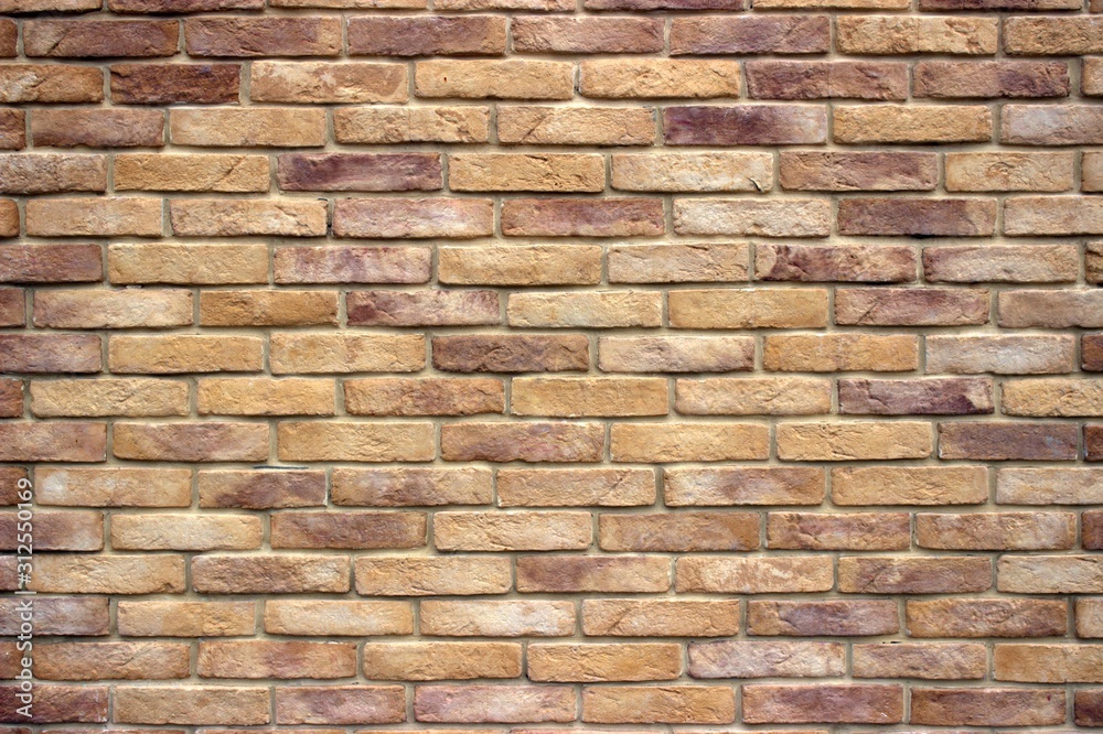 A brick wall consisting of bricks of various shades of brown. Antique decorative background or retro style. A brick wall consisting of bricks of various shades of brown. Antique decorative background or retro style.