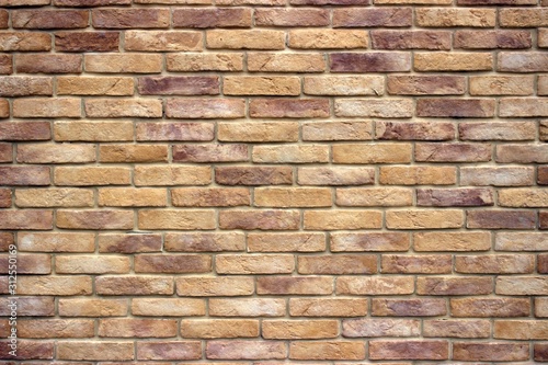  A brick wall consisting of bricks of various shades of brown. Antique decorative background or retro style.