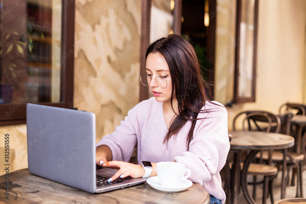 Beautiful attractive woman at the cafe with a laptop having a coffee break