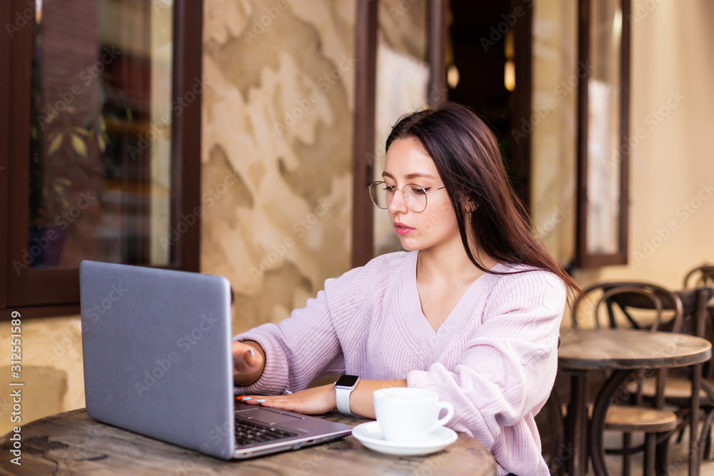 Beautiful attractive woman at the cafe with a laptop having a coffee break Beautiful attractive woman at the cafe with a laptop having a coffee break