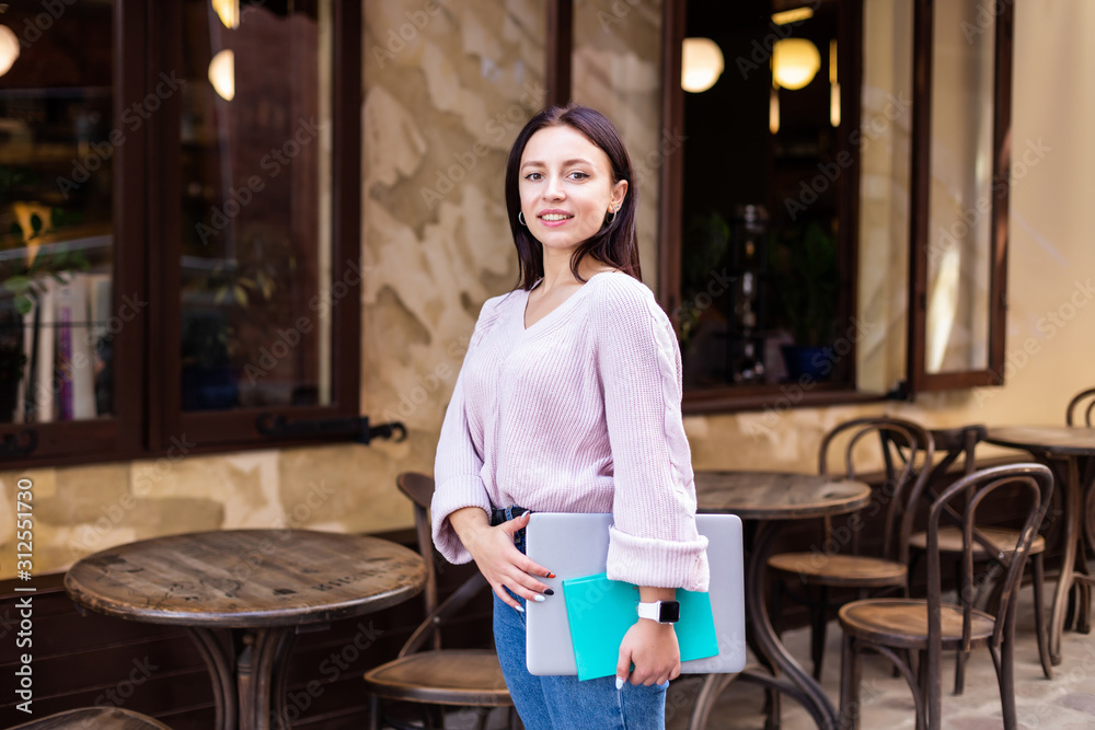 Happy student woman holding folders walking on the street Happy student woman holding folders walking on the street