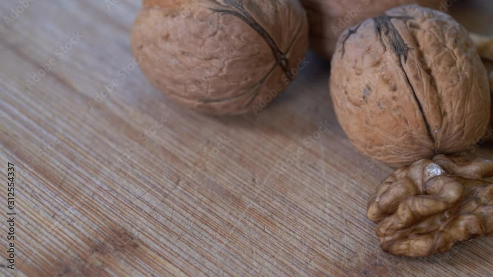 Top view of walnuts rotating on a wooden background. Peeled walnut kernels and whole walnut close up video. Natural, healthy and raw food concept Top view of walnuts rotating on a wooden background. Peeled walnut kernels and whole walnut close up video. Natural, healthy and raw food concept