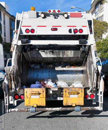 Obraz na plátně Rear view of American garbage collection truck on urban street.