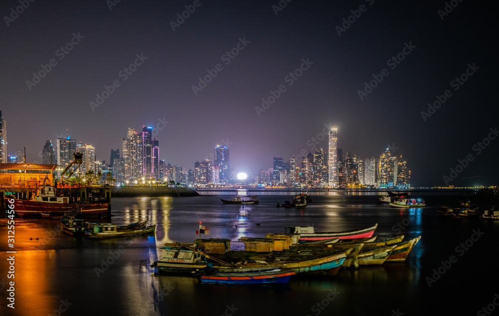 boats and city skyline at night -  cityscape of Panama City  business district - illuminated skyscraper buildings ,