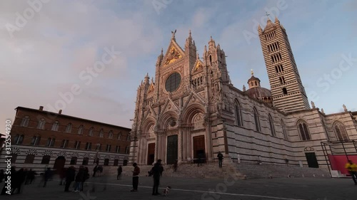 Many tourists walking by in front of the Cathedral of Siena