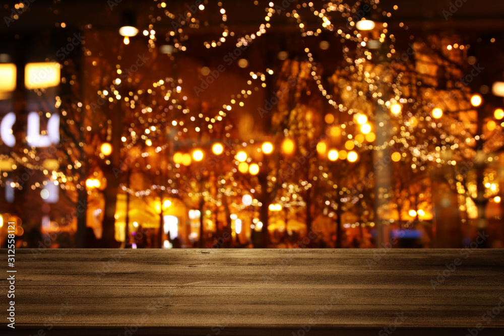background Image of wooden table in front of street view in front of abstract blurred lights
