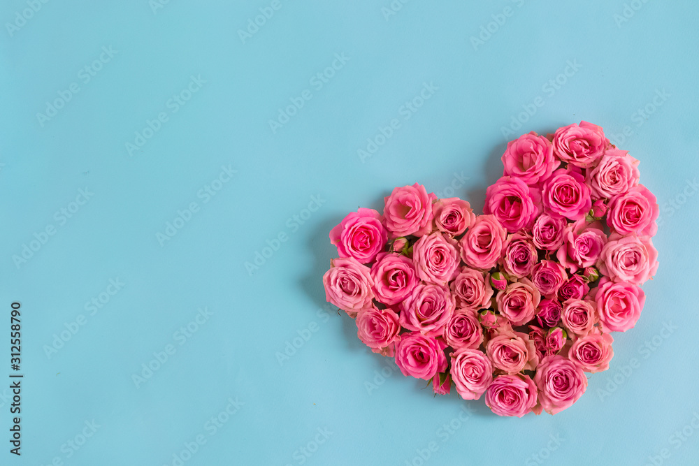 Valentine's day romantic greeting card. Composition with a heart of pink roses on a blue background.Mothers day. 8 Marth. Banner for advertising store, website, posters, advertising, coupons. Valentine's day romantic greeting card. Composition with a heart of pink roses on a blue background.Mothers day. 8 Marth. Banner for advertising store, website, posters, advertising, coupons.