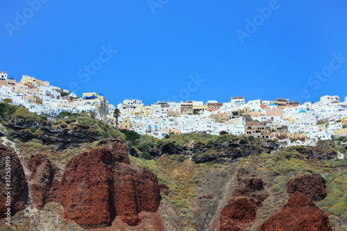 Wybrzeża greckiej wyspy Santorini z usytuowanymi na klifach miasteczkami Oia i Thira #312559119