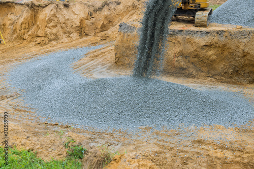 Moving gravel excavator in the construction works of a foundation of the house photo