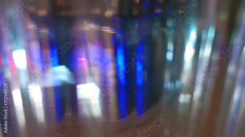 Dynamic blurred video. Flashing colored lights, neon behind the glass. Motion video. Colorful garlands. Blurred view. Bright illuminated scene. Abstract background, backdrop for any purpose 