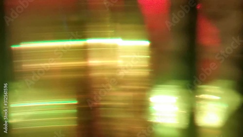 Dynamic blurred video. Flashing colored lights, neon behind the glass. Motion video. Colorful garlands. Blurred view. Bright illuminated scene. Abstract background, backdrop for any purpose 