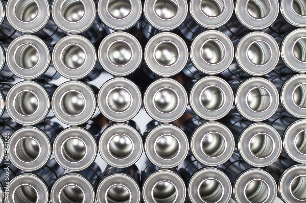 A large number of aerosol cans on a black background. A large number of aerosol cans on a black background.