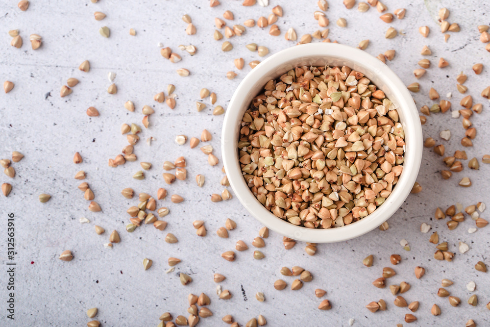 Buckwheat in a white bowl on a gray background, top view Buckwheat in a white bowl on a gray background, top view