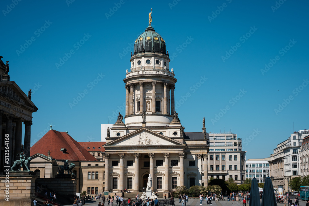 People at the  French Cathedral at Gendarmenmarkt on a sunny summer day in Berlin
