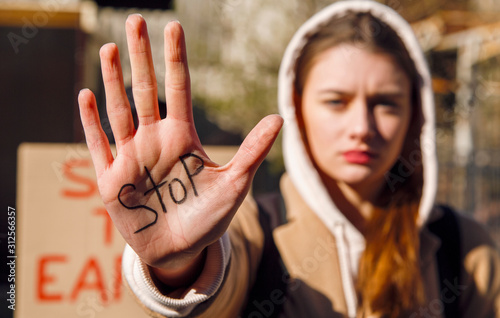 Young woman showing hand with word Stop photo