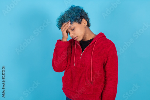 young afro american woman with hands on head in pain expression isolated on color background