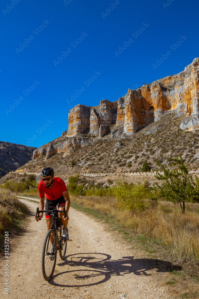 Fototapeta premium Ciclista pedaleando por el cañón del río Riaza