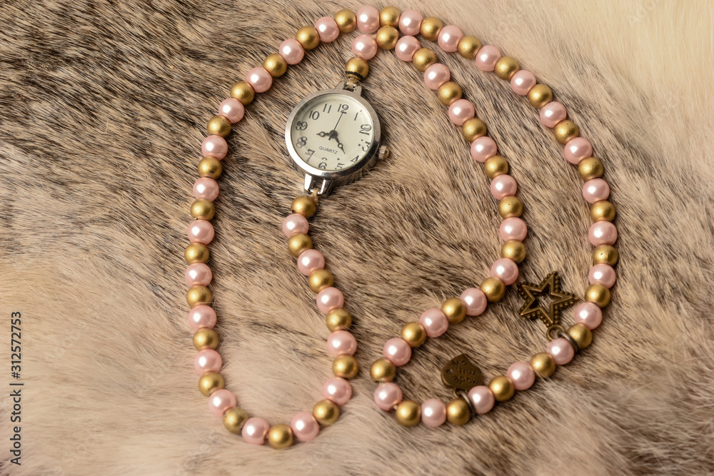 Fototapeta premium Wrist watch with white beads and rice