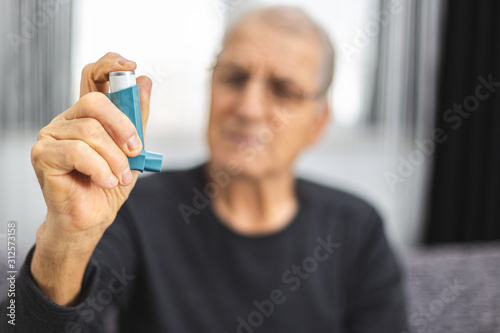 Elderly person using an asthma spray photo