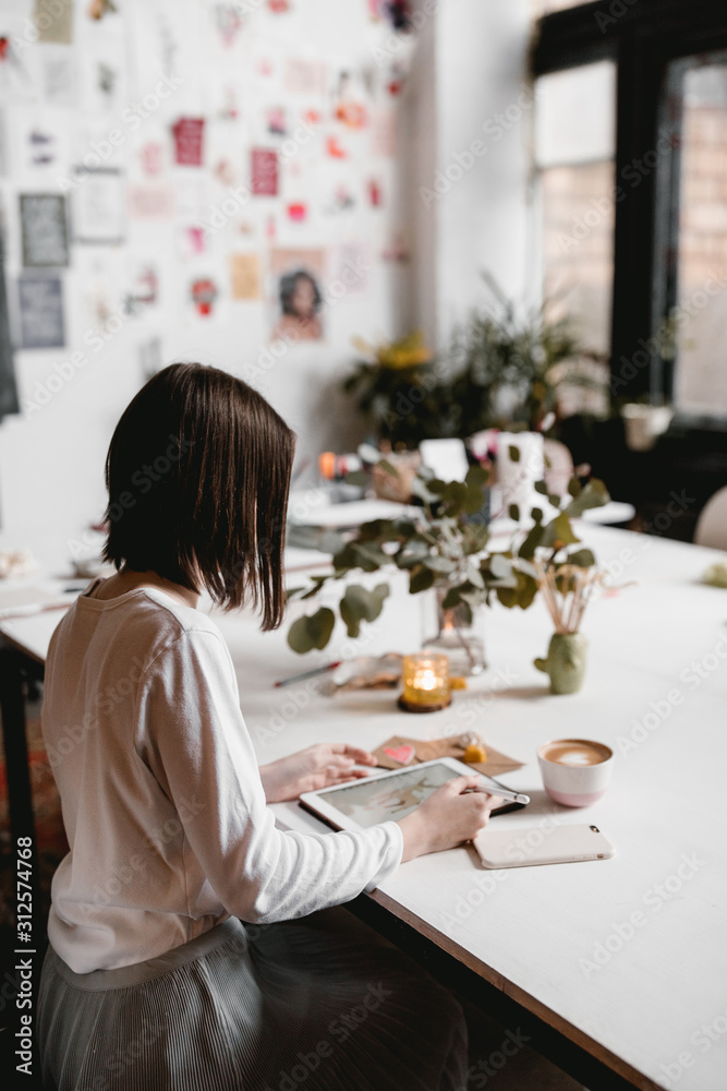 Girl browsing tablet on table with valentine decor Girl browsing tablet on table with valentine decor