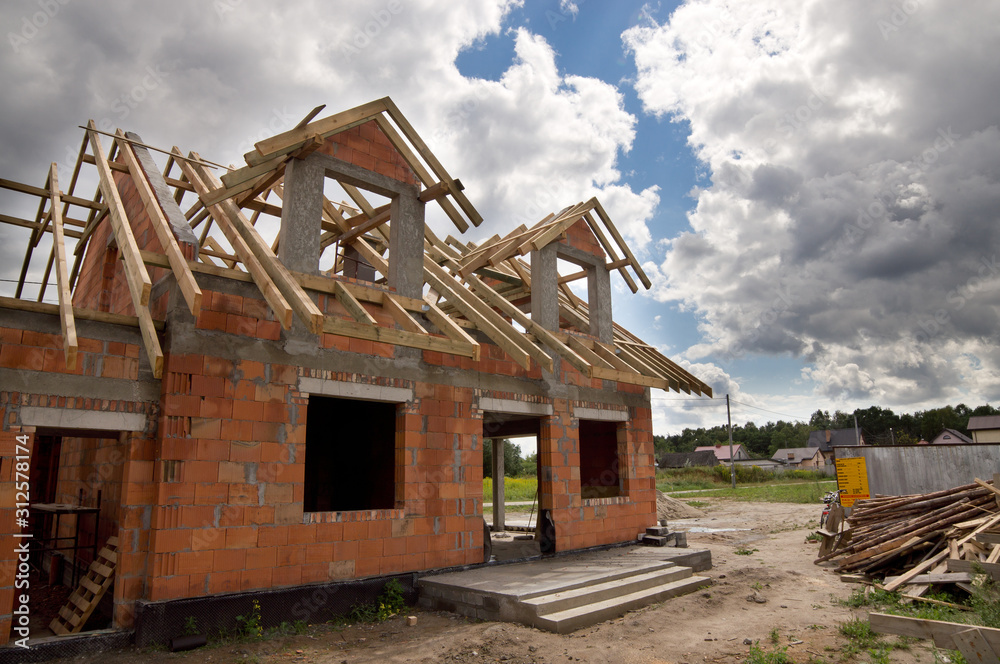 Fototapeta premium Dom w trakcie budowy z drewnianą więźbą dachową