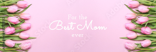 For the best Mom ever wording with pink tulips on the pink background. Flat lay, top view. Mother's day holiday celebration card. Horizontal, banner format © Ekaterina_Molchanova
