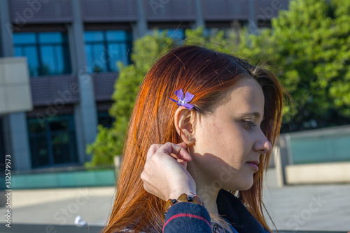 A beautiful girl is using flower on ear as ornament