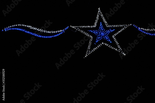 estrella con luces de navidad sobre fondo negro. felices fiestas.