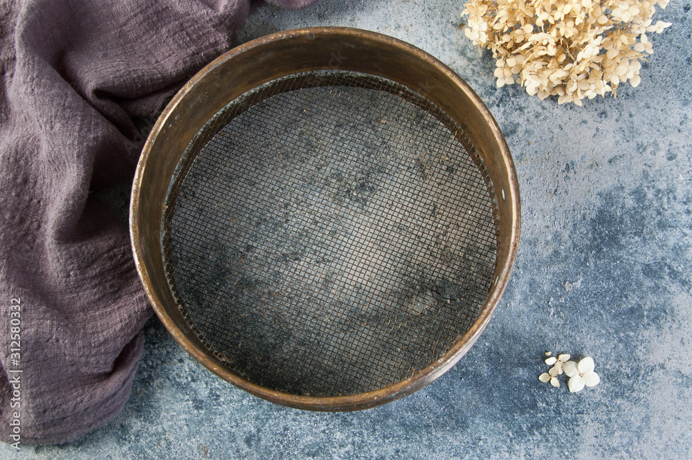 Antique brass sieve on concrete background. Antique brass sieve on concrete background.