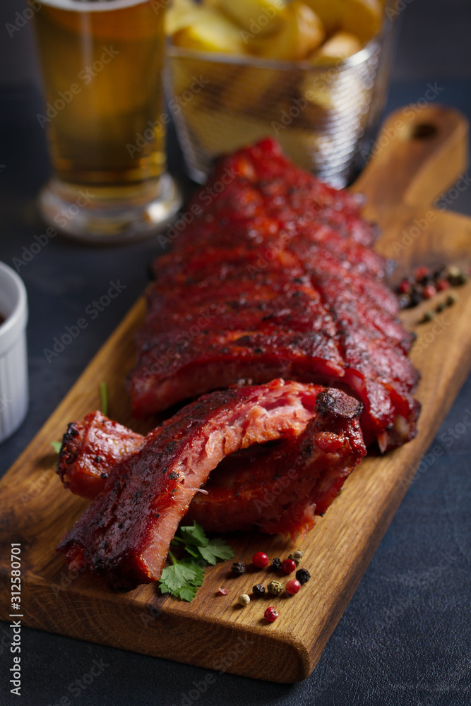Rack of ribs, barbecue sauce, fries and light beer. Vertical image