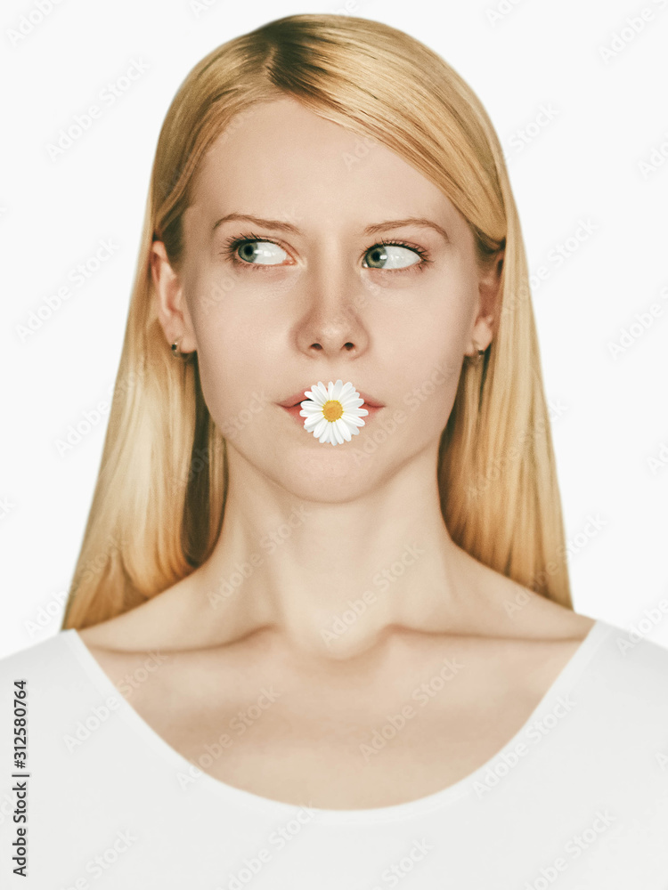Blonde girl with flower Crop portrait Young woman with fair skin is holding a daisy flower in her mouth Blonde girl with flower Crop portrait Young woman with fair skin is holding a daisy flower in her mouth