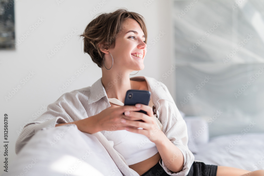 Young pretty girl use phone message in the dark sitting on a couch at home Young pretty girl use phone message in the dark sitting on a couch at home