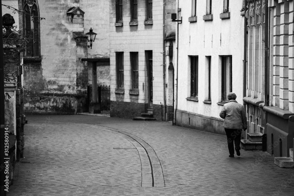 old woman walking down a european city street