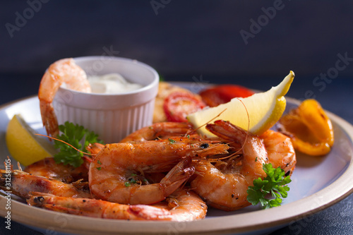 Shrimps with sauce, lemon and vegetables. Seafood photo