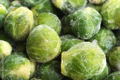 Frozen Brussels sprouts as background, closeup. Vegetable preservation