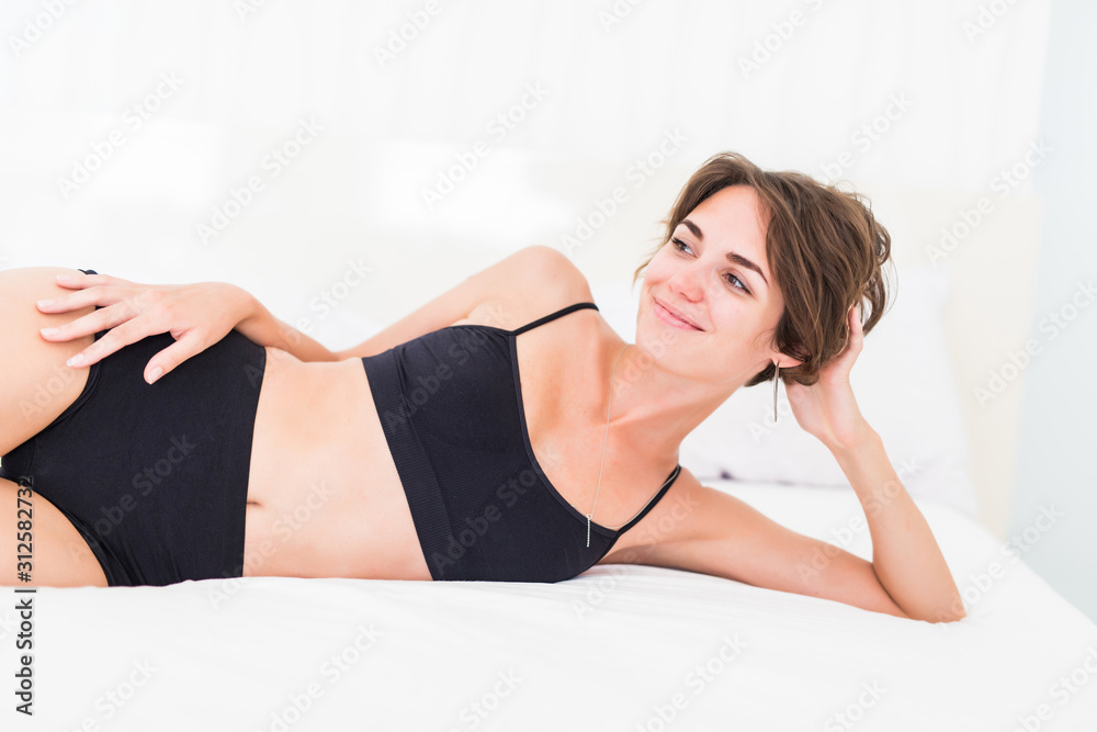 Beautiful young woman lying in black lingerie in the bed Beautiful young woman lying in black lingerie in the bed