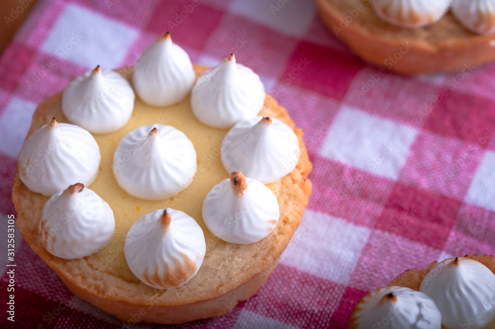 Elegant cupcakes with lemon Kurd and meringue scorched by a flame. Very tasty cupcakes. Tartlet filled with lemon cream (Kurd) and meringue
