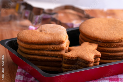 Preparation for the holiday. Baked gingerbread cookies for the new year. Gingerbread blanks before drawing. Gingerbread cookies with holes for hanging on a Christmas tree. Holiday preparation. photo