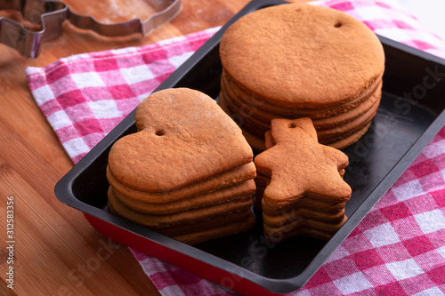 Preparation for the holiday. Baked gingerbread cookies for the new year. Gingerbread blanks before drawing. Gingerbread cookies with holes for hanging on a Christmas tree. Holiday preparation. photo