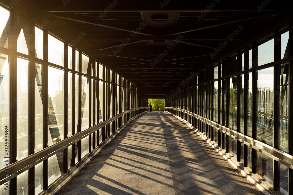 pedestrian pathway above highway, golden light shining creating shadows pedestrian pathway above highway, golden light shining creating shadows
