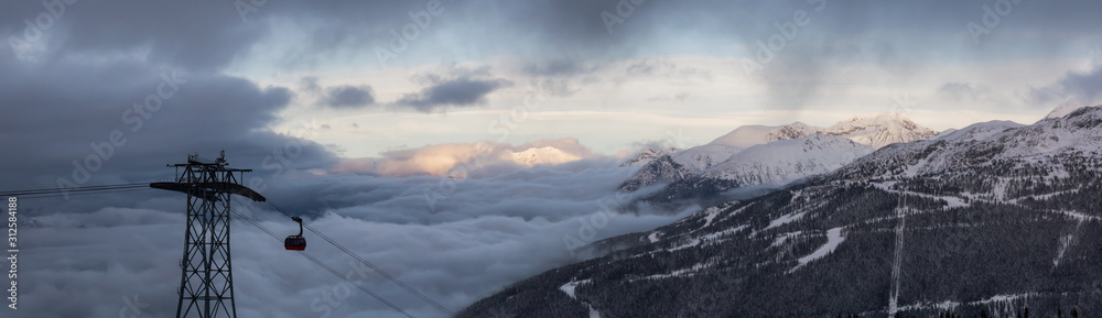 Whistler, British Columbia, Canada. Beautiful View of Peak to Peak Gondola with the Canadian Snow Covered Mountain Landscape during a cloudy and foggy winter day.