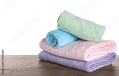 Fresh towels on wooden table against white background