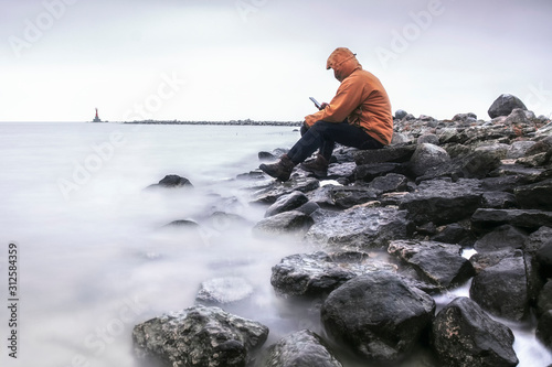 a lonely man sits on the seashore