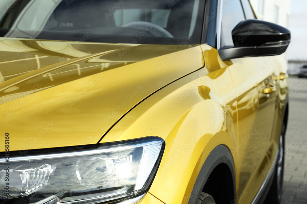New modern golden car on city street, closeup New modern golden car on city street, closeup
