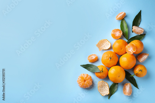 Fresh ripe tangerines on light blue background, flat lay. Space for text