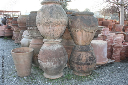 open air workshop of ceramics, earthenware, orange and brown terracotta flower pots