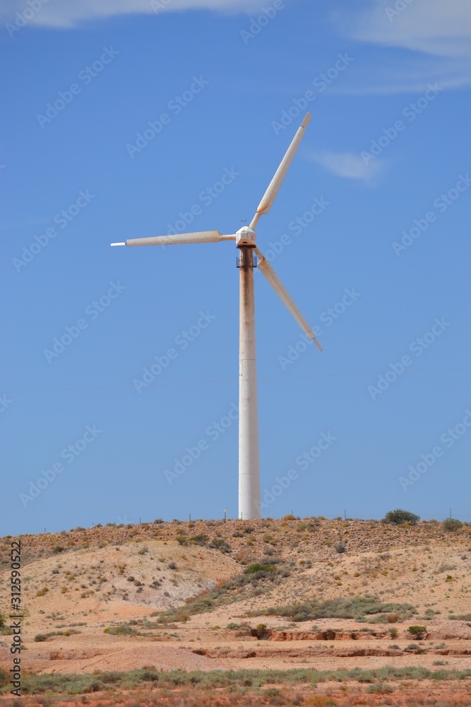 Lone wind turbine against a blue sky near the outback town of Coober Pedy in South Australian desert Lone wind turbine against a blue sky near the outback town of Coober Pedy in South Australian desert