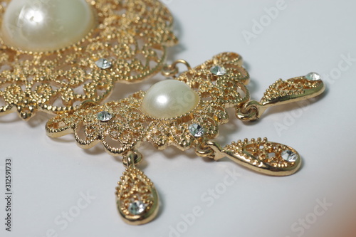 Golden broche with pearl and diamond on a white isolated background