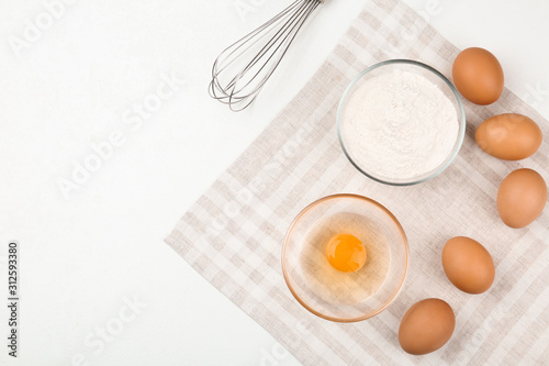 Flat lay composition with raw eggs and other ingredients on white table. Baking pie